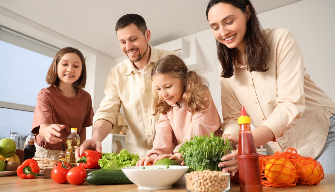 Parents and children preparing a meal together as part of a family-focused approach to nutrition and essential nutritional building blocks.